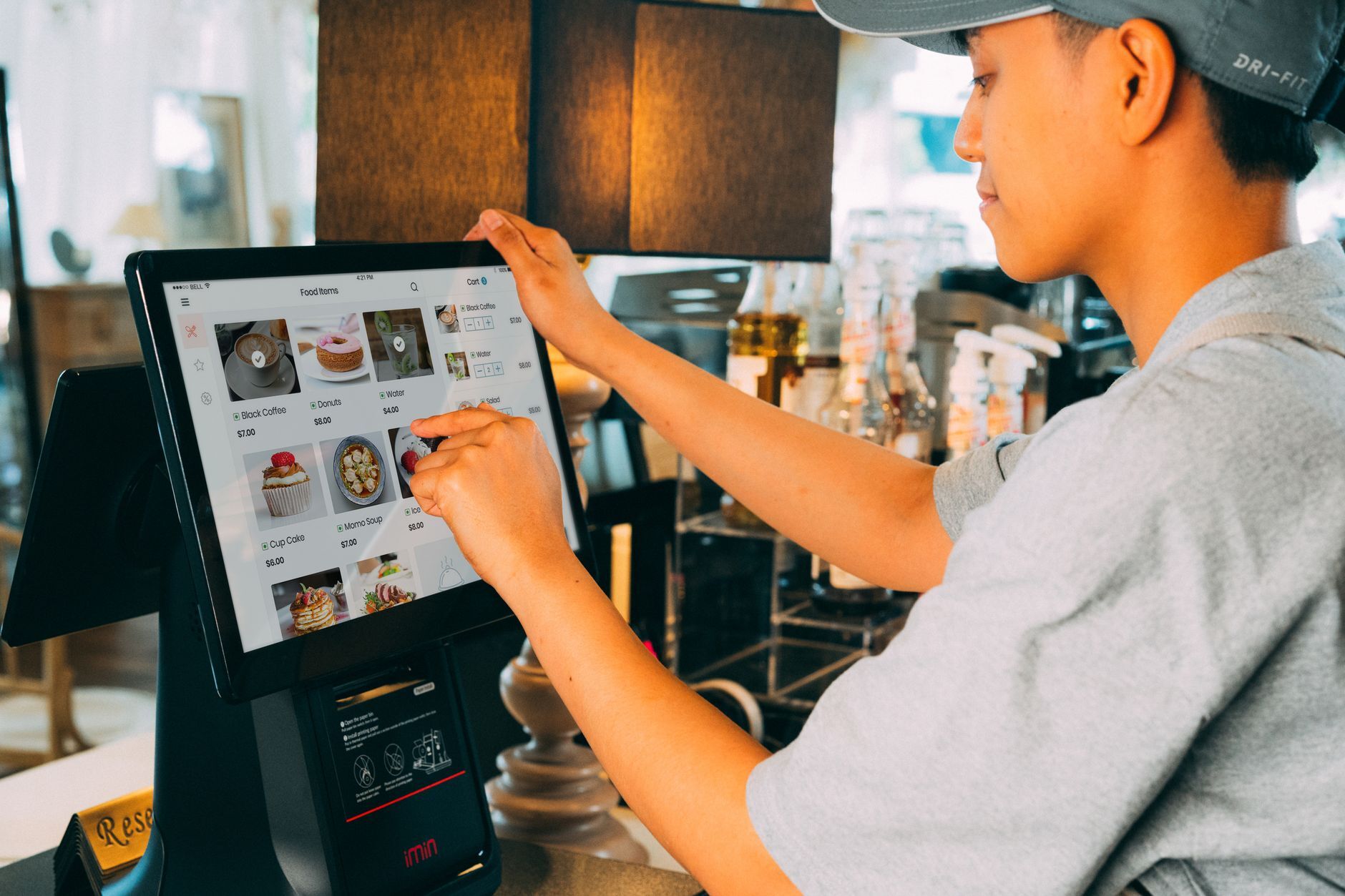 A cafe worker navigating a modern touchscreen system to manage orders efficiently. Photo by iMin Technology on Pexels
