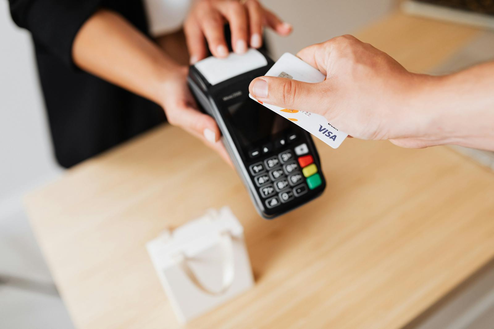 A person making a contactless payment with a credit card